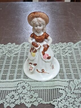 Vintage Woolbro‎ porcelain figurine bell featuring a girl in a brown dress.
